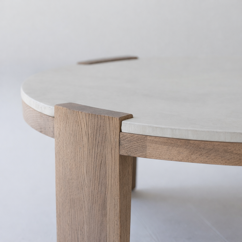 Luxury round stone center table with oak wood legs styled for Ramadan hosting in UAE