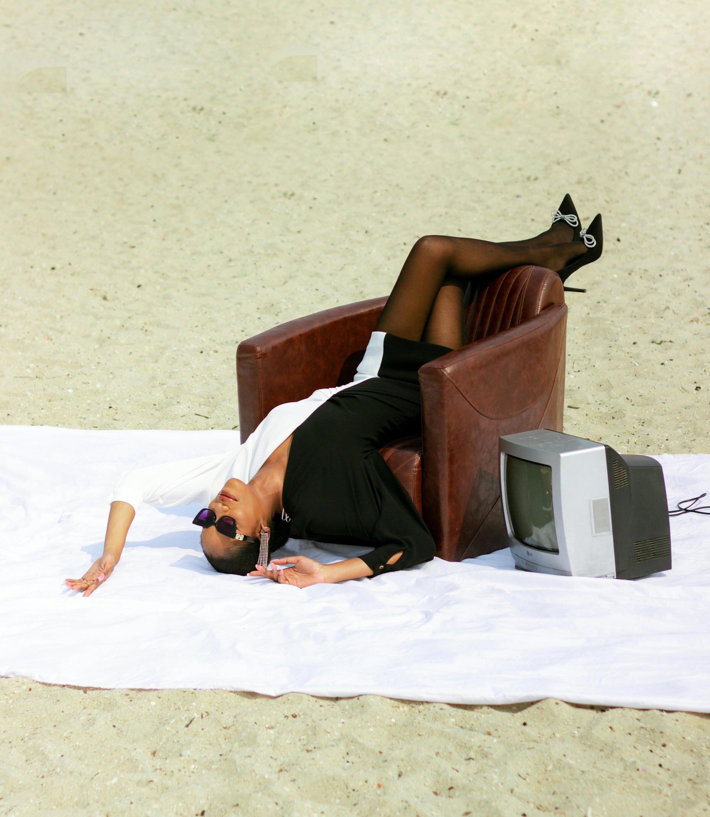 Luxury leather armchair styled on beach with model, handcrafted premium single sofas by The Meem Store Dubai.