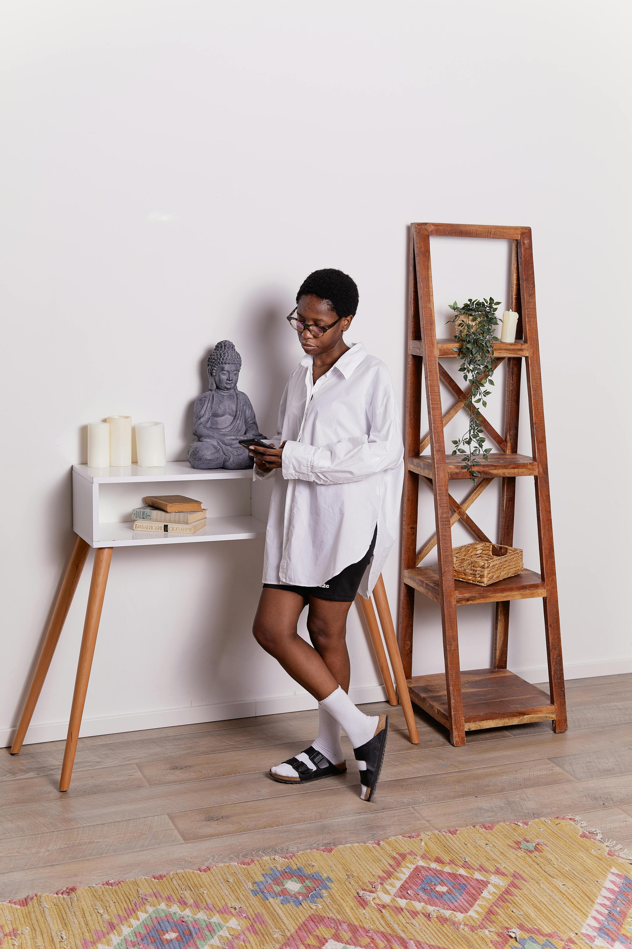 Lifestyle setup featuring a modern console table showcase storage open cabinet, with a model using her mobile — luxury storage furniture from The Meem Store Dubai.